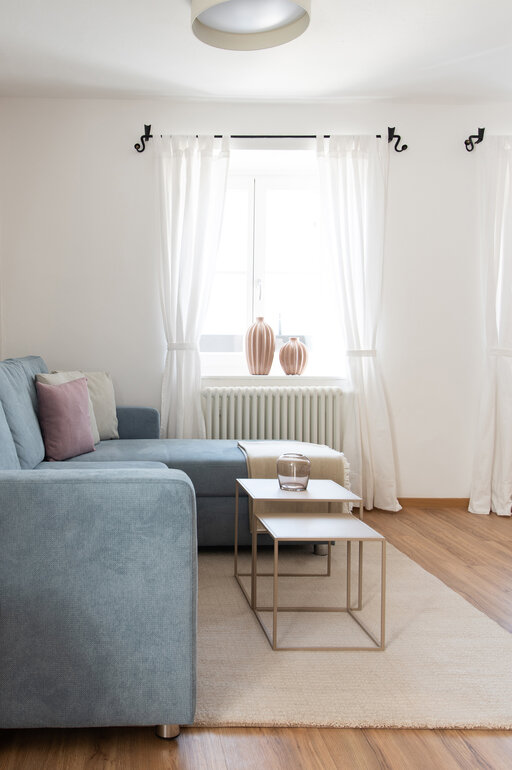 Helles Wohnzimmer mit eleganter Einrichtung und großen Fenstern