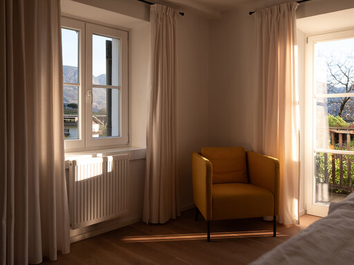 Lichtdurchflutetes Schlafzimmer mit gemütlichem Leseplatz