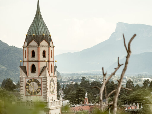 Der berühmte Kirchturm von Meran mit Blick auf die Berge